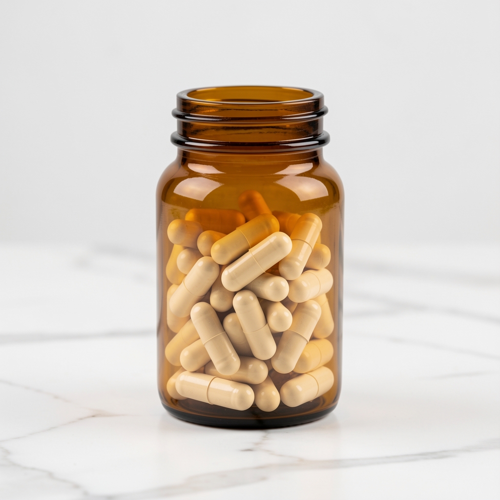 Supplement capsules in amber glass bottle arranged on a white marble surface with clean studio lighting